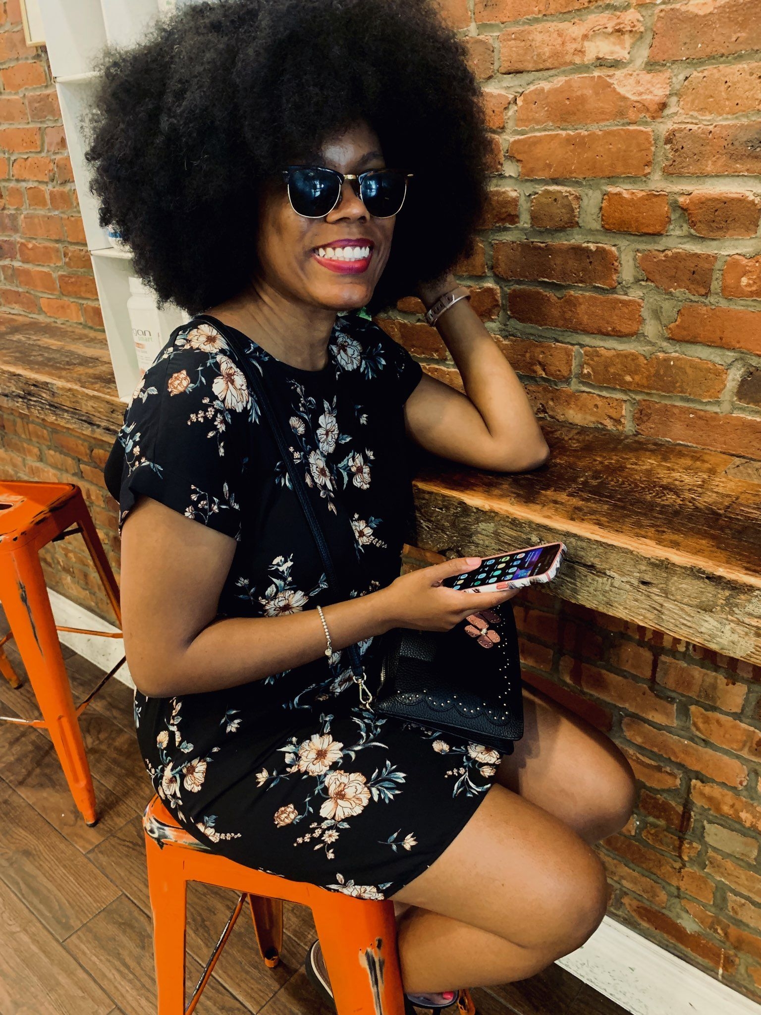 woman with an afro with smartphone in her hand